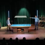 to mænd omkring poolbord i teaterstykke
